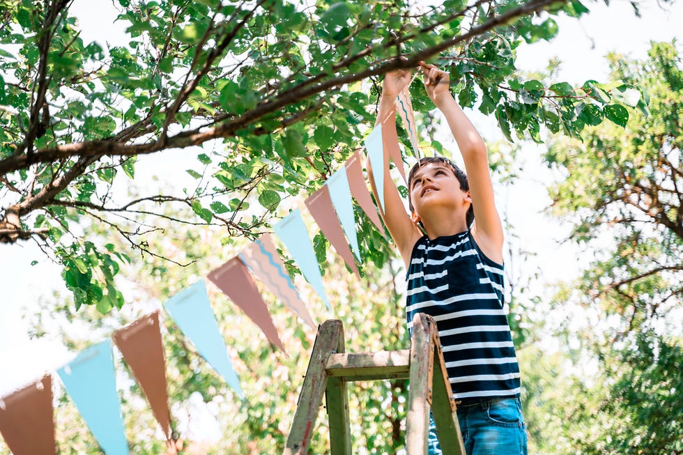 young boy putting up bunting
