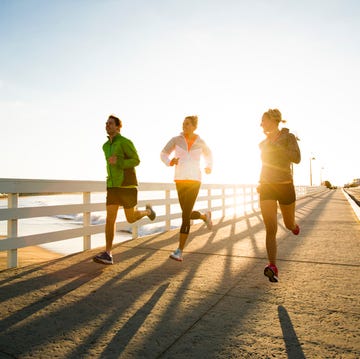 Jogging along the coast. friends running a boardwalk near the pacific ocean