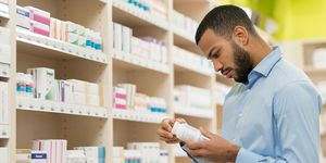 beard man choosing supplement in drugstore supplement probiotics prebiotics differences