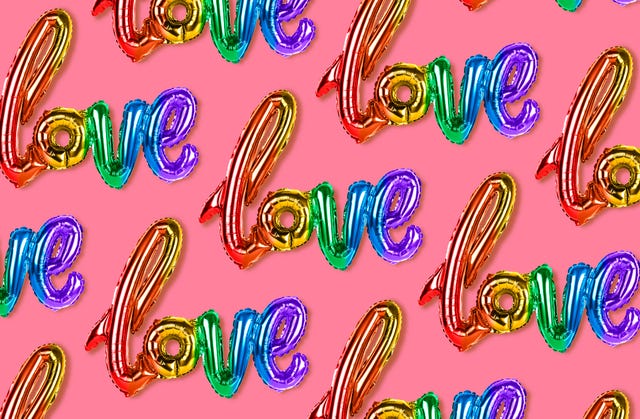 inscription love, rainbow balloons on pink background