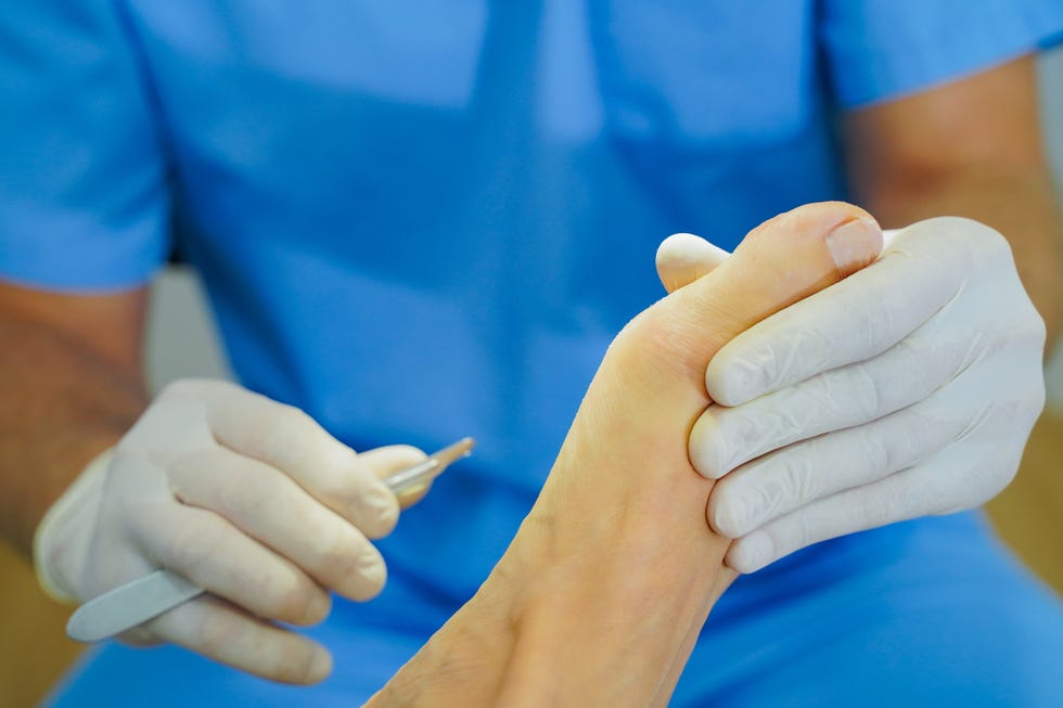 blond woman attends the podiatry specialist for pain in the soles of her feet