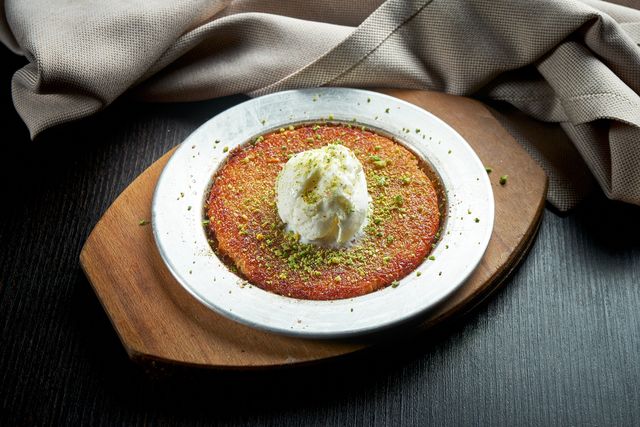 appetizing turkish sweetness kanafeh made with shredded filo pastry with honey, pistachios and white ice cream