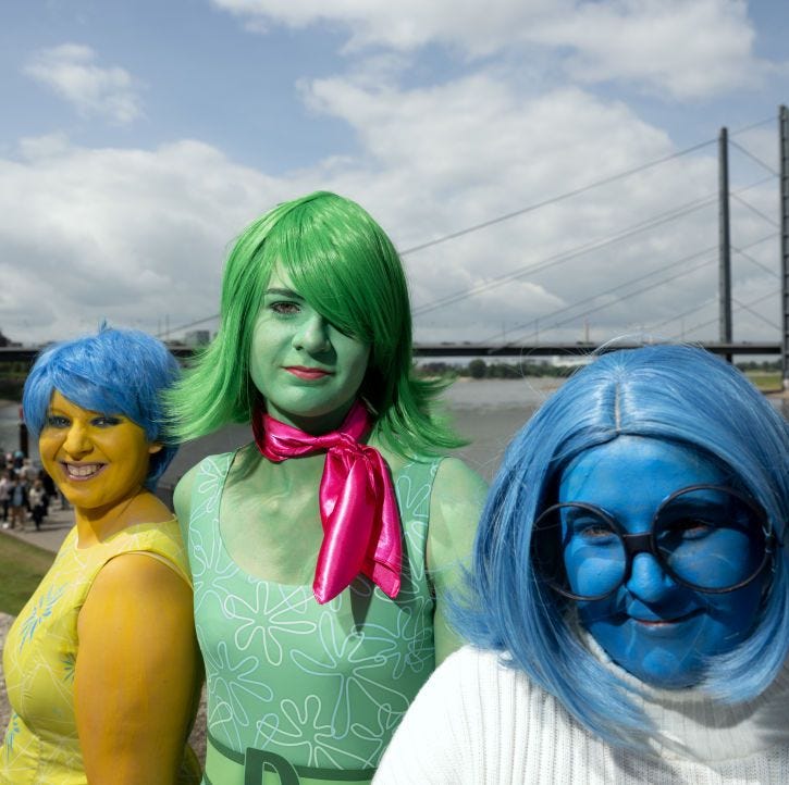 Group of people dressed in inside-out costumes, including joy, sadness and disgust