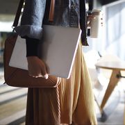 woman carrying laptop, purse and reusable coffee cup to work