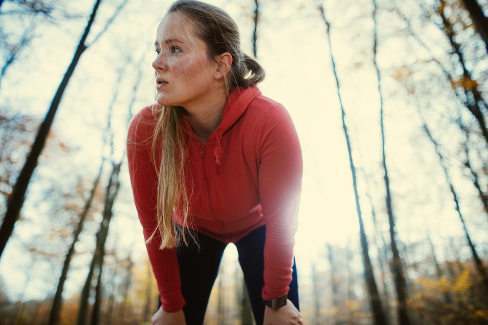 long blondhaired exhausted woman after jogging in autumnal park