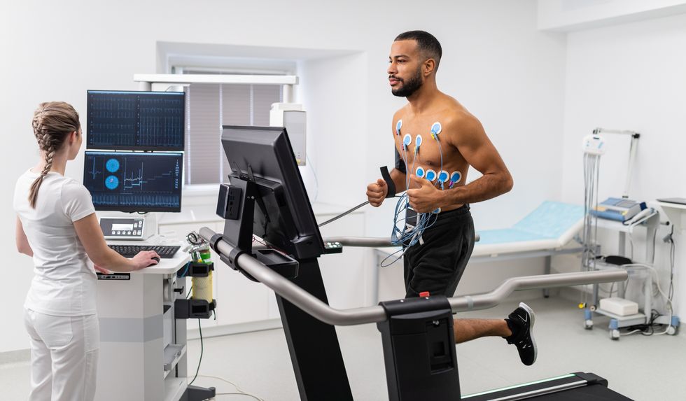 athlete does a cardiac stress test in a medical study, monitored by the female doctor