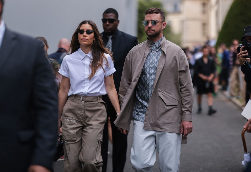 paris, france   june 24 jessica biel l seen wearing a black sunglasses, a white cotton blouse shirt from dior and a beige cargo pants justin timberlake r seen wearing a silver sunglasses, a silver diamond necklace, a beigebrown trench jacket, a bluewhite dior logo shirt blouse and a white denim jeans pants, outside the dior homme show, during paris fashion week   menswear springsummer 2023 on june 24, 2022 in paris, france photo by jeremy moellergetty images