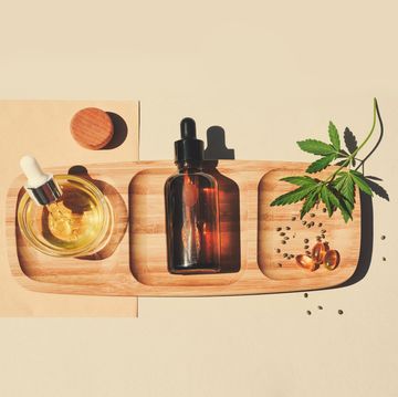 cbd oil, tincture with marijuana leaves on a beige background cannabis seeds in a wooden spoon medical cannabis concept for health and cosmetics minimalism