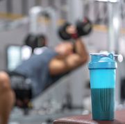 whey protein at gym with young asian man working out his chest muscle  in the background
