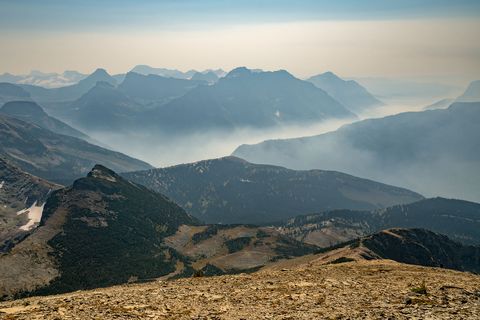 wildfire smoke fills up valley in vast mountains of glacier national park, montana, usa on a hot dry day of summer climate change impact global warming