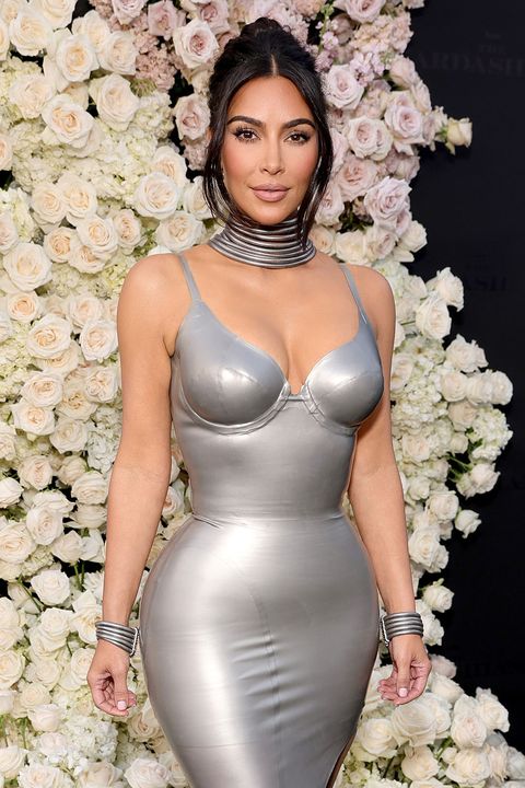 kim kardashian attends the los angeles premiere of the kardashians on hulu in 2022 wearing a form fitting silver gown