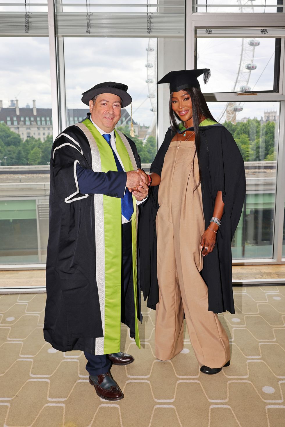 london, england   july 07 professor bashir makhoul, president  vice chancellor of uca, and naomi campbell celebrate as naomi campbell officially became dr naomi campbell as she was formally awarded an honorary phd from the university for the creative arts in recognition of her contribution to the global fashion industry the doctorate was presented to her at the graduation of uca epsom students at the royal festival hall on july 7, 2022 in london, england for the ceremony, naomi wore a burberry biscuit colour wool tailored jacket with orange lapels, waistcoat, and a beige jumpsuit, with biscuit colour leather boots make up by pat mcgrath labs photo by david m benettdave benettgetty images for burberry  outside org