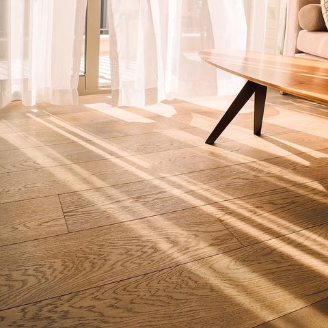 light streams in from a window onto a floor made of solid wood
