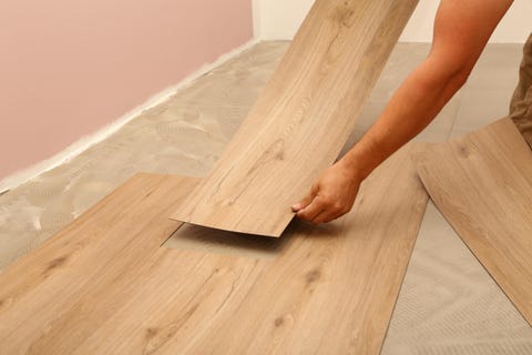 a professional install planks of laminate flooring with a wood pattern