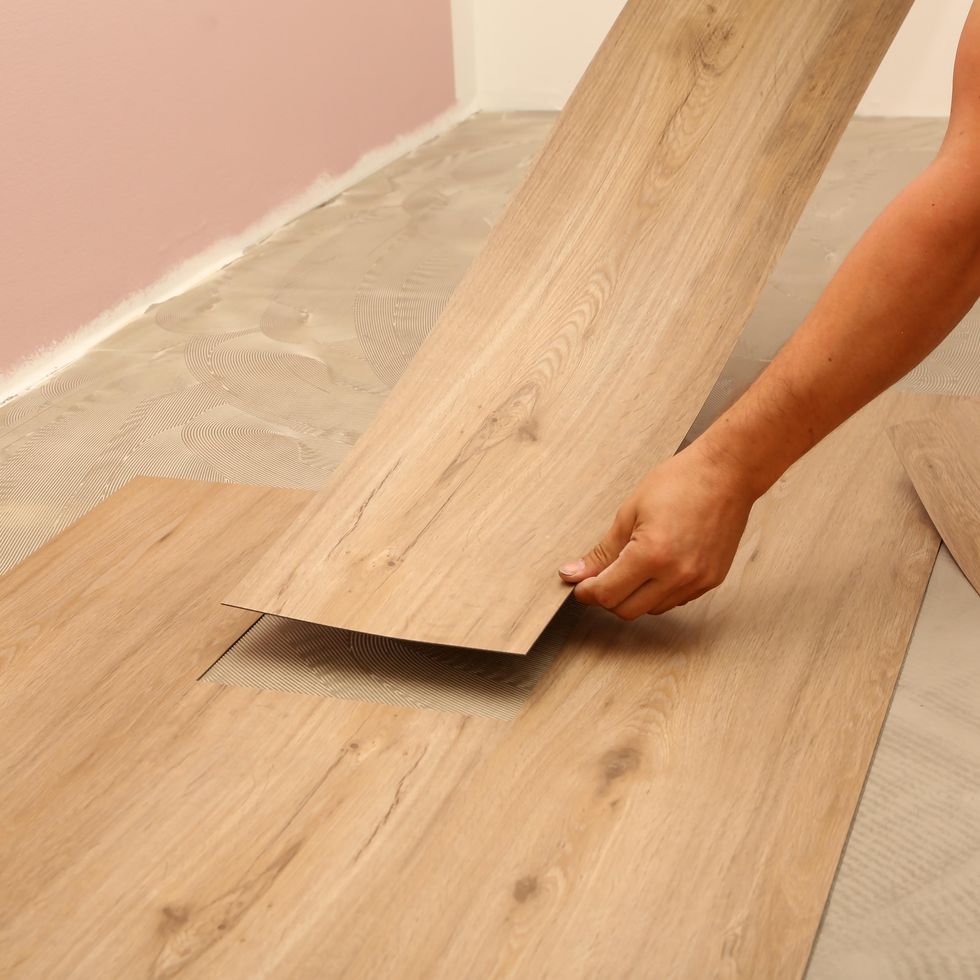a professional install planks of laminate flooring with a wood pattern