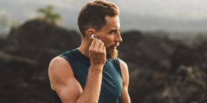 man using wireless earphones air pods on running outdoors active lifestyle concept