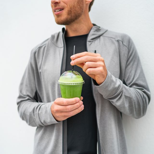 healthy young man drinking green juice smoothie cup as weight loss detox meal replacement diet spinach protein shake for morning breakfast