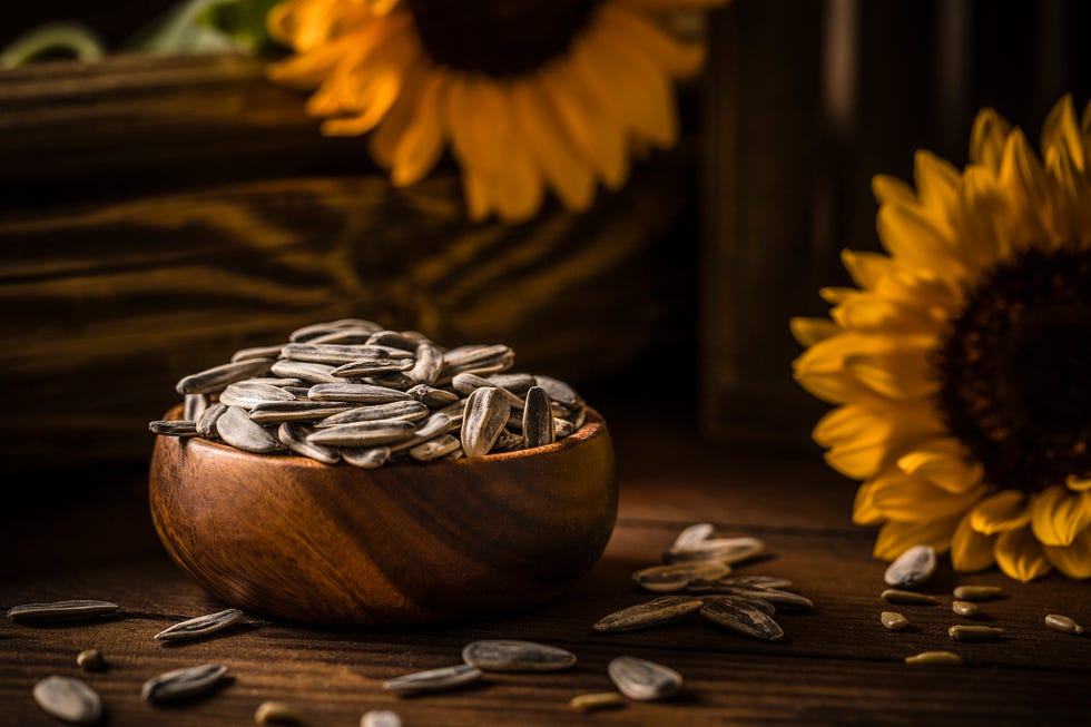 front view of a wooden bowl full of sunflower seeds