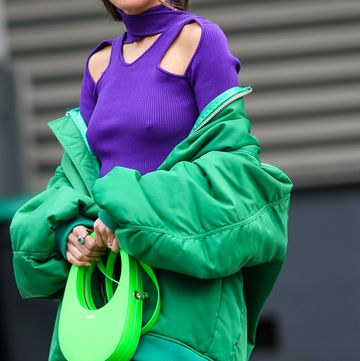 paris, france   march 03 alexandra pereira wears silver and gold earrings, a neon purple turtleneck  cut out chest and shoulder  long sleeveless  tube midi dress, a green oversized bomber coat, a neon green shiny leather handbag from coperni, silver and diamonds rings, outside coperni, during paris fashion week   womenswear fw 2022 2023, on march 03, 2022 in paris, france photo by edward berthelotgetty images