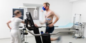 young adult man having a vo2 test with a vo2 mask on his face, electrocardiogram pads attached, treadmill