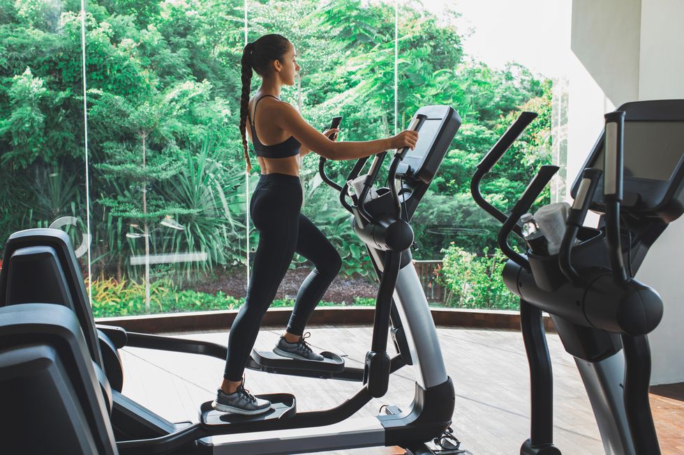 woman training on stepper or treadmill in fitness club of gym side view power and endurance functional cardio training woman health