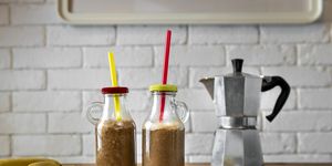 homemade coffee banana smoothies with dactyls or white brick wall background