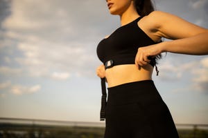 close up on a woman  putting on a fitness tracker to monitor her calories and heart rate   fitness goals concepts