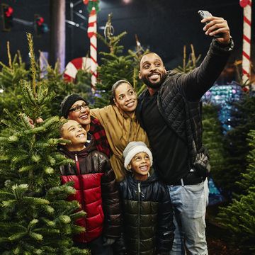 multigenerational family taking selfie while shopping for christmas tree