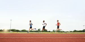 tre runner corrono sulla pista di atletica