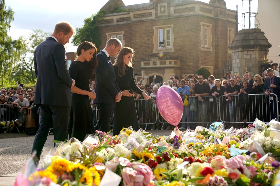 windsor, england   september 10 prince harry, duke of sussex, meghan, duchess of sussex, catherine, princess of wales and prince william, prince of wales view floral tributes left at windsor castle on september 10, 2022 in windsor, england crowds have gathered and tributes left at the gates of windsor castle to queen elizabeth ii, who died at balmoral castle on 8 september, 2022 photo by kirsty oconnor   wpa poolgetty images