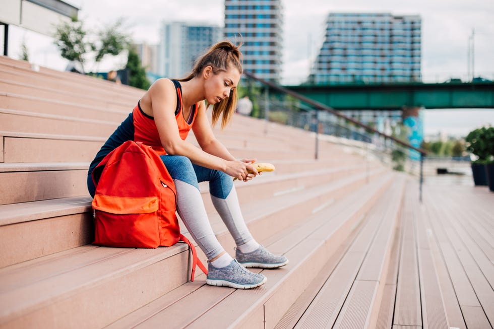 young girl holding a banana before a workout