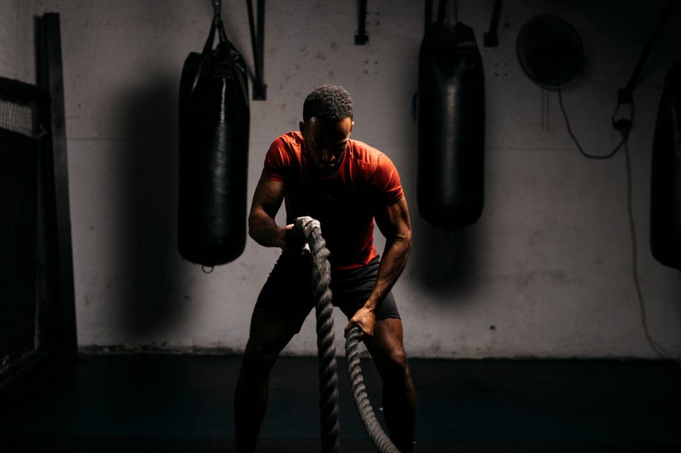 black male workingout with battle ropes in a gym