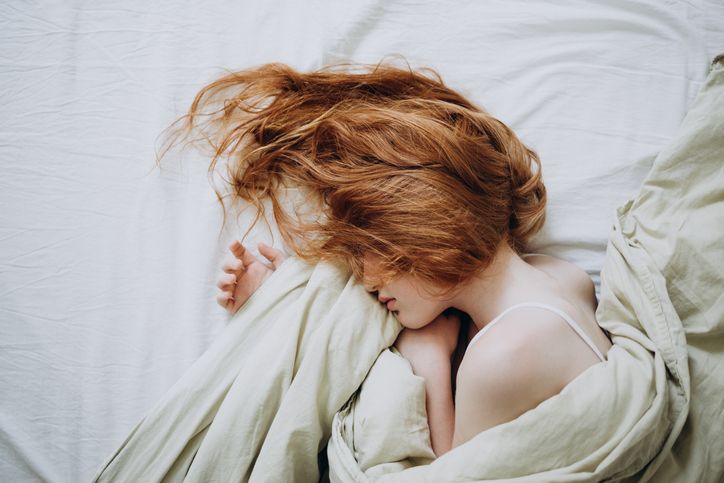 red haired little girl wakes up in the morning in her crib