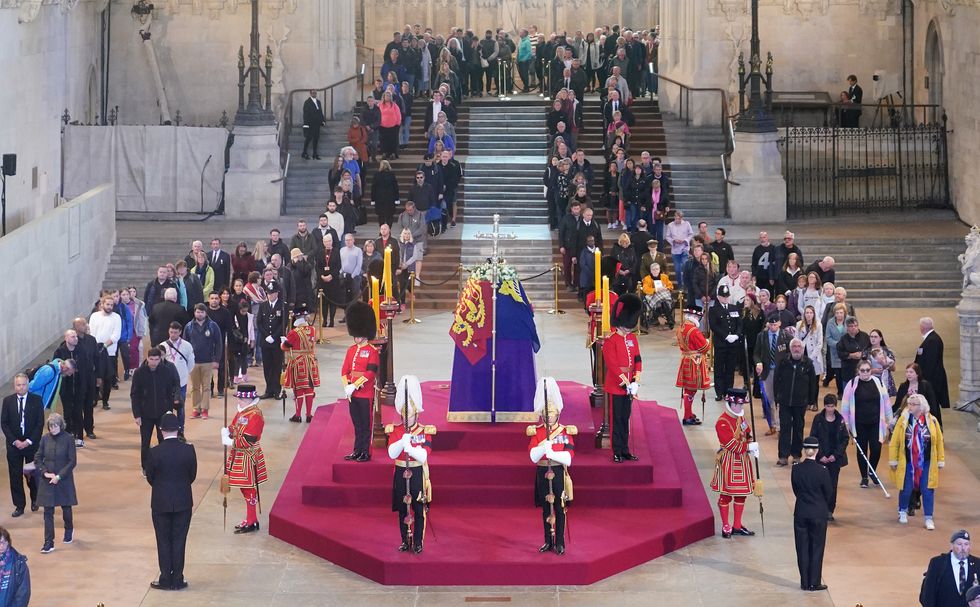 london, england   september 16  members of the public file past the coffin of queen elizabeth ii, draped in the royal standard with the imperial state crown and the sovereign's orb and sceptre, lying in state on the catafalque in westminster hall, at the palace of westminster, ahead of her funeral on monday, on september 16, 2022 in london, england members of the public are able to pay respects to her majesty queen elizabeth ii for 23 hours a day until 0630 on september 19, 2022  queen elizabeth ii died at balmoral castle in scotland on september 8, 2022, and is succeeded by her eldest son, king charles iii photo by yui mok   wpa poolgetty images