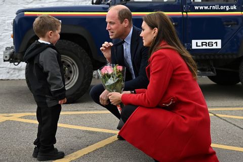 holyhead, wales   september 27 prince william, prince of wales c gestures as his wife catherine, princess of wales is presented with a posy of flowers by four year old theo crompton during their visit to the rnli royal national lifeboat institution holyhead lifeboat station, during a visit to wales on september 27, 2022 in holyhead, wales  photo by paul ellis   wpa pool  getty images