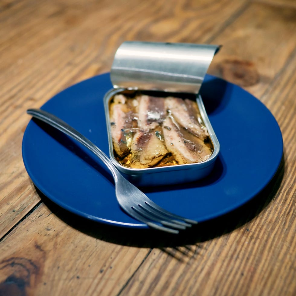 Premium Photo  Old can opener and tin can with food on a white background  closeup