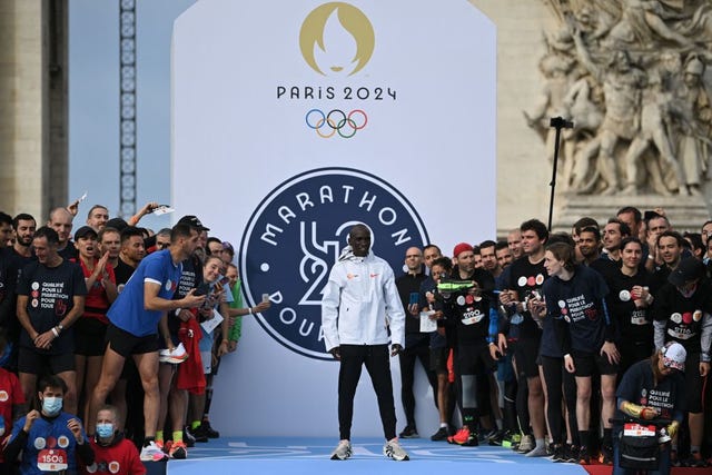 topshot   winners pose with reigning two time olympic champion and marathon world record holder kenyas eliud kipchoge following  the j 1000 paris 2024  marathon pour tous or marathon for all, a 5kms run along the champs elysees, in paris on october 31, 2021   runners, who started the race before the olympian, had to cross the finish line before him to win an entry bib for the upcoming paris 2024 mass participation marathon photo by anne christine poujoulat  afp photo by anne christine poujoulatafp via getty images