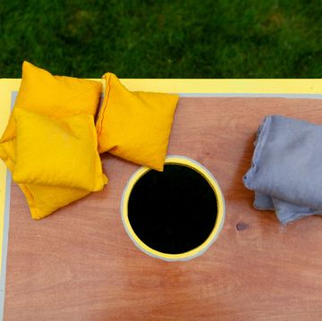 above view of a cornhole game with yellow and gray beanbags