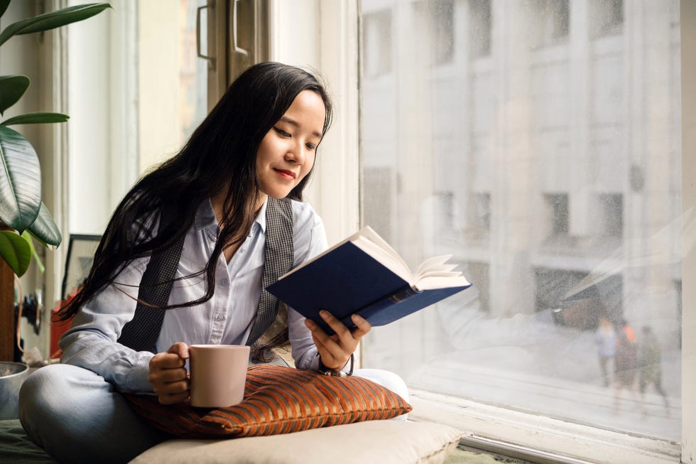 young woman in blue jeans reading