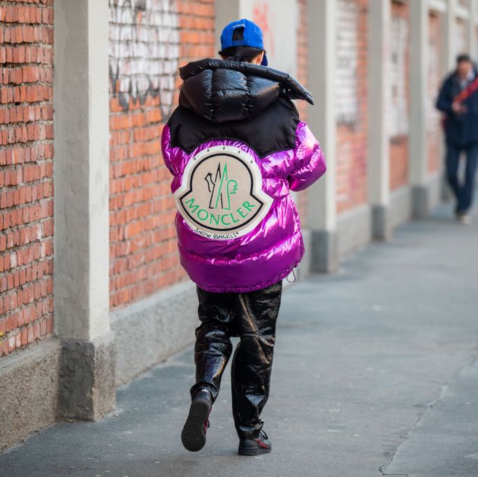 milan, italy   january 13 a guest is seen wearing black pink down feather puffer jacket moncler, varnish pants, blue cap outside fendi during milan fashion week fallwinter 20202021 on january 13, 2020 in milan, italy photo by christian vieriggetty images
