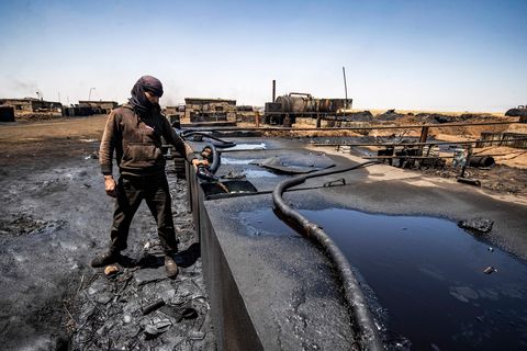 a man works at a makeshift refinery using burners to distill crude oil in the village of bishiriya in the countryside near the town of qahtaniya west of rumaylan rmeilan in syrias kurdish controlled northeastern hasakeh province, on july 19, 2020   oil pollution in syria has become a growing concern since the 2011 onset of a civil war that has taken a toll on oil infrastructure and seen rival powers compete over control of key hydrocarbon fields in the kurdish held northeast, a large storage facility in the rmeilan oil field in hasakeh province is of particular concern, with leaks from the gir zero storage facility have been suspected since at least 2014, and the latest just in march 2020 photo by delil souleiman  afp photo by delil souleimanafp via getty images