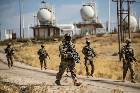 mask clad us soldiers walk during a military patrol near an oil production facility in the countryside near al malikiyah derik in syrias northeastern hasakah province on october 27, 2020 photo by delil souleiman  afp photo by delil souleimanafp via getty images