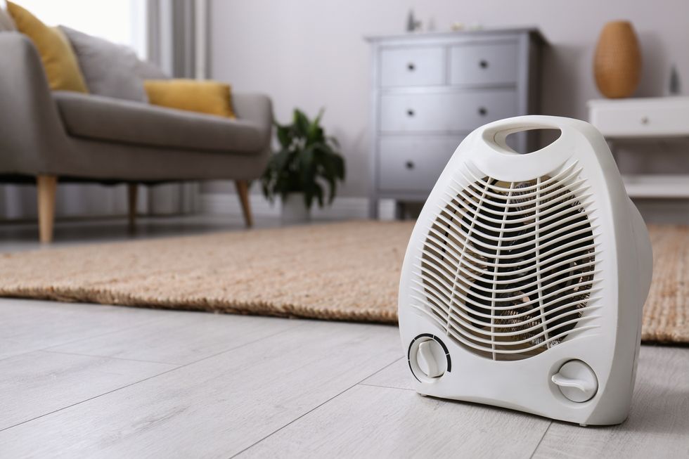 modern electric fan heater on floor at home space for text