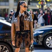 paris, france   october 04 cindy bruna wears black laced dress, belt, brown shearling jacket with silver application outside miu miu during paris fashion week   womenswear springsummer 2023  day nine on october 04, 2022 in paris, france photo by christian vieriggetty images