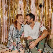 new years decoration ideas laughing couple in front of photo backdrop on new year's eve
