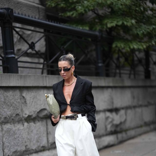new york, new york september 09 a guest wears sunglasses, a black oversized blazer jacket, a belt, white shorts, mesh shoes, a green bag, outside khaite , during new york fashion week, on september 09, 2023 in new york city photo by edward berthelotgetty images
