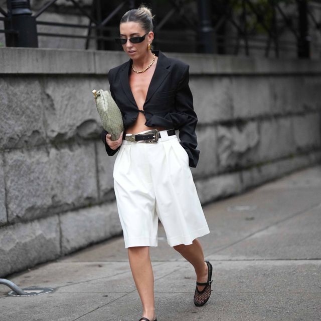 new york, new york september 09 a guest wears sunglasses, a black oversized blazer jacket, a belt, white shorts, mesh shoes, a green bag, outside khaite , during new york fashion week, on september 09, 2023 in new york city photo by edward berthelotgetty images