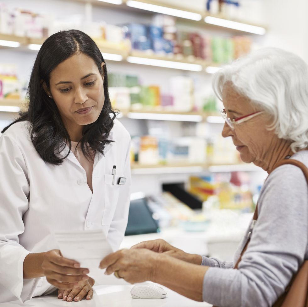 january holidays pharmacist helping woman with her prescription