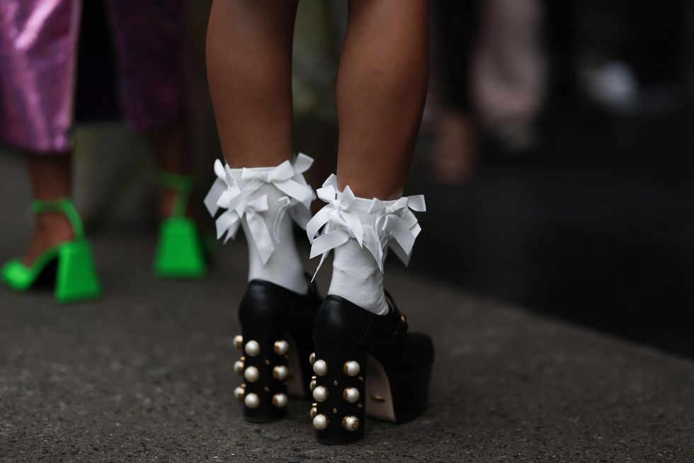 new york september 09 a fashion week guest is seen wearing a black mini skirt, white socks with several bows and black leather platform heels from gucci with pearl details on the heels outside bevor the patbo show on september 09, 2023 in new york city photo by jeremy moellergetty images