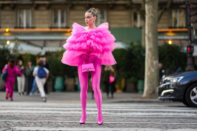 paris, france september 30 sira pevida wears silver large earrings, a neon pink ruffled oversized tulle top, neon pink nylon pointed heels pants shoes, a neon pink shiny leather crocodile print pattern hourglass handbag from balenciaga, neon pink gloves , outside giambattista valli, during paris fashion week womenswear springsummer 2023, on september 30, 2022 in paris, france photo by edward berthelotgetty images